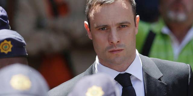 FILE - In this Friday, Oct. 17, 2014 file photo, Oscar Pistorius is escorted by police officers as he leaves the high court in Pretoria, South Africa. Prison officials have recommended that Pistorius be released from prison on Aug. 21 to go under house arrest. Acting National Commissioner of Correctional Services Zach Modise says that a prison committee recommended Pistorius be released after serving one sixth of his five-year sentence, or 10 months, for shooting girlfriend Reeva Steenkamp. A decision by the parole board is pending. (AP Photo/Themba Hadebe, File)