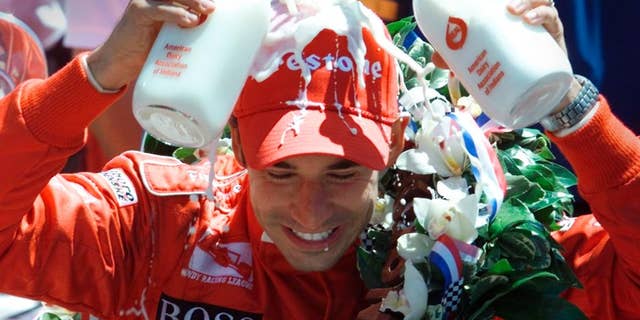 FILE - In this May 26, 2002, file photo, Indianapolis 500 champion Helio Castroneves of Brazil pours two bottles of milk onto his head after winning his second consecutive Indianapolis 500 auto race, in Indianapolis. (AP Photo/Michael Conroy, File)