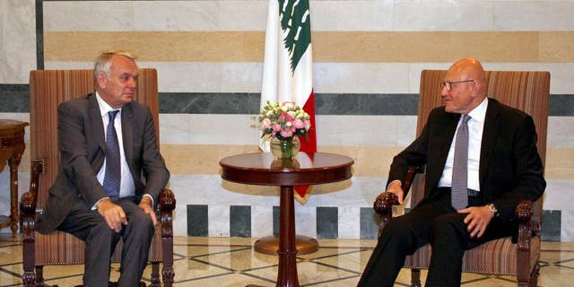 In this photo released by Lebanon's official government photographer Dalati Nohra, Lebanese Prime Minister Tammam Salam, right, meets with French Foreign Minister Jean-Marc Ayrault, left, at the government House, in Beirut, Lebanon, Tuesday, July 12, 2016. Ayrault said his country will do everything it can to help Lebanon emerge from its political stalemate. (Dalati Nohra via AP)