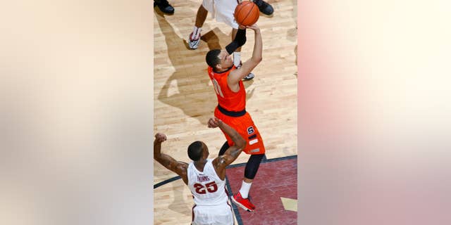 Syracuse guard Tyler Ennis (11), who had 16 points, shoots by Florida State guard Aaron Thomas (25) in the first half of an NCAA college basketball game Sunday, March 9, 2014, at the Donald L. Tucker Center in Tallahassee, Fla. Syracuse defeated Florida State 74-58. (AP Photo/Phil Sears)