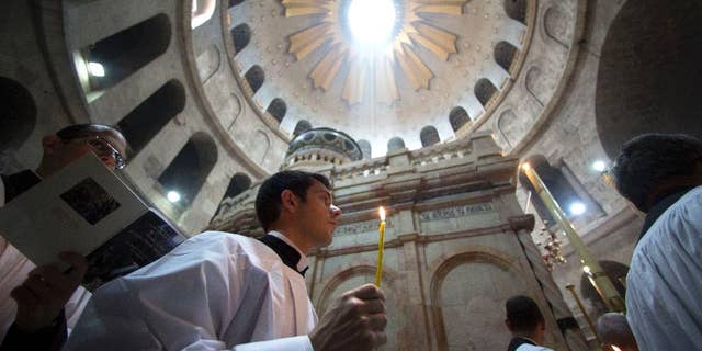 Christian pilgrims light candles during the Easter Sunday procession at the Church of the Holy Sepulchre, traditionally believed by many Christians to be the site of the crucifixion and burial of Jesus Christ, in Jerusalem, Sunday, April 16, 2017. (AP Photo/Sebastian Scheiner)