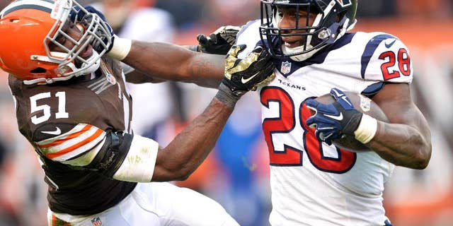 Houston Texans running back Alfred Blue (28) fights for yardage against Cleveland Browns outside linebacker Barkevious Mingo (51) in the fourth quarter of an NFL football game Sunday, Nov. 16, 2014, in Cleveland. (AP Photo/David Richard)