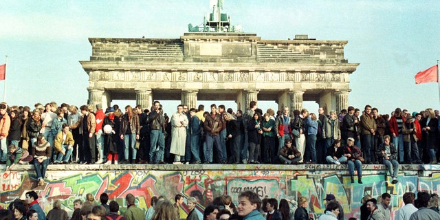West Berlin citizens continue their vigil atop the Berlin Wall in front of the Brandeburg Gate in this November 10, 1989 file photo. The 10th anniversary off the "fall" of the Berlin wall is coming up on November 9, 1999.
