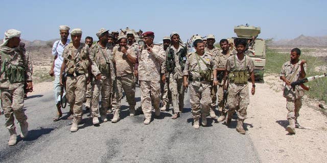 In this Friday, May 1, 2014, photo provided by Yemen's Defense Ministry, army officers and soldiers patrol a road during fighting with al-Qaida militants in Majala of the southern province of Abyan, Yemen. (AP Photo/Yemen's Defense Ministry)