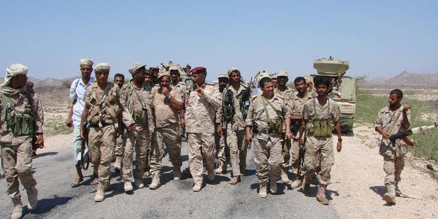 In this Friday, May 1, 2014, photo provided by Yemen's Defense Ministry, army officers and soldiers patrol a road during fighting with al-Qaida militants in Majala of the southern province of Abyan, Yemen. (AP Photo/Yemen's Defense Ministry)