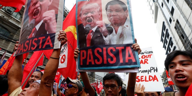 Protesters shout slogans holding portraits of U.S. President Donald Trump and Philippines President Rodrigo Duterte during a rally near the U.S. Embassy in Manila, Nov. 10, 2017. The sign translates to "Fascist."