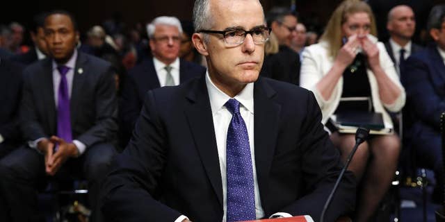 Acting FBI Director Andrew McCabe sits with a folder marked