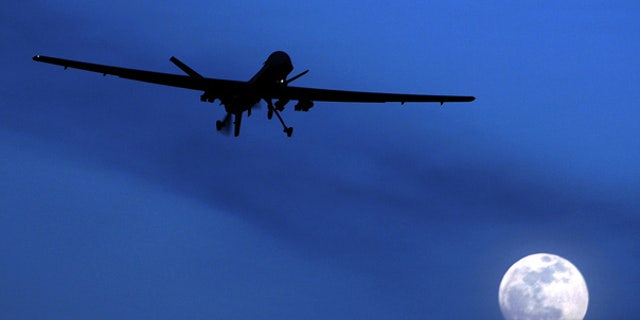A U.S. Predator drone flies over the moon above Kandahar Air Field, Afghanistan.