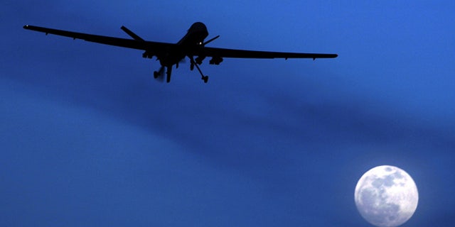 A U.S. Predator drone flies over the moon above Kandahar Air Field, Afghanistan.