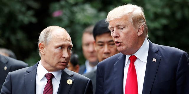 U.S. President Donald Trump and Russia's President Vladimir Putin talk during the family photo session at the APEC Summit in Danang, Vietnam November 11, 2017. 