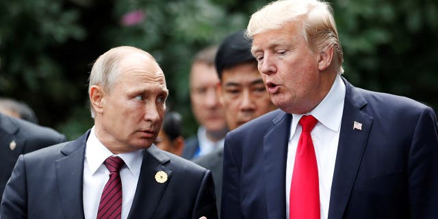 U.S. President Donald Trump and Russia's President Vladimir Putin talk during the family photo session at the APEC Summit in Danang, Vietnam November 11, 2017. 