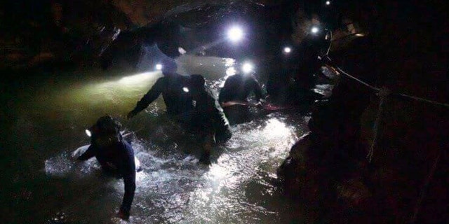 In this handout photo released by Tham Luang Rescue Operation Center, Thai rescue teams walk inside a cave complex where 12 in Mae Sai, Chiang Rai province, in northern Thailand, Monday, July 2, 2018.