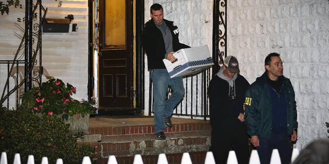FILE - In a Thursday, Oct. 10, 2013 file photo, FBI agents remove evidence from the Brooklyn residence of Rabbi Mendel Epstein during an investigation, in New York. Several defendants, including Epstein and another rabbi, are accused by the FBI of plotting to kidnap and beat a man to force him to grant a religious divorce. Epstein’s trial starts Tuesday, Feb. 17, 2015, in federal court in New Jersey. Several co-defendants have pleaded guilty and others will join him in court this week. (AP Photo/John Minchillo, File)