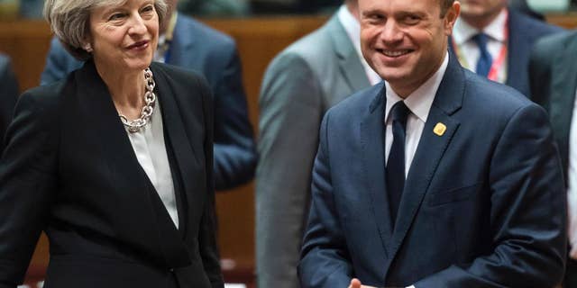 FILE - This is a Thursday, Dec. 15, 2016 file photo of British Prime Minister Theresa May, left, speaks with Malta's Prime Minister Joseph Muscat, during a round table meeting at an EU Summit in Brussels . Muscat the leader of the European Union’s smallest nation warned Britain on Wednesday Jan. 11, 2016 that it can only lose by leaving the EU and that no member state is likely to break ranks and negotiate with London until it has departed. (AP Photo/Geert Vanden Wijngaert, File)