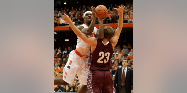 Syracuse’s C.J. Fair, left, hits Colgate’s Clayton Graham as Fair shoots in the first half of an NCAA college basketball game in Syracuse, N.Y., Saturday, Nov. 16, 2013. (AP Photo/Nick Lisi)
