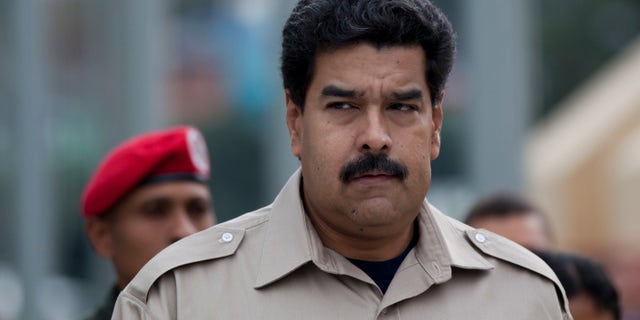 En imagen del martes 5 de noviembre de 2013, el presidente venezolano Nicolás Maduro llega al museo militar para visitar la tumba de su antecesor Hugo Chávez en Caracas. El mandatario ordenó a las autoridades tomar control de la cadena de tiendas Daka, a cuyos propietarios acusa de especular. (Foto de AP/Ariana Cubillos)