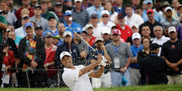 Tiger Woods hits out of the bunker on the first hole during the second round of the PGA Championship golf tournament at Valhalla Golf Club on Friday, Aug. 8, 2014, in Louisville, Ky. (AP Photo/Jeff Roberson)