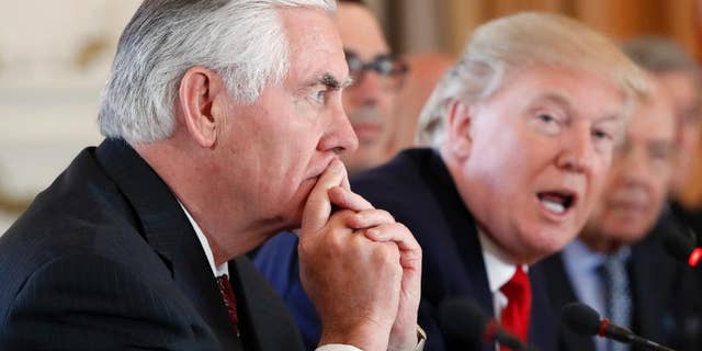 Secretary of State Rex Tillerson, left, listens as President Donald Trump speaks at Mar-a-Lago, April 7, 2017, in Palm Beach, Fla.