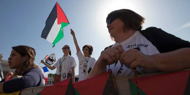 Pilgrims wait for Pope Francis arrival to celebrate a canonization ceremony of four new saints in St. Peter's Square at the Vatican, Sunday, May 17, 2015. Among them are Arab nuns Sts. Mariam Bawardy and Marie Alphonsine Ghattas, who lived in what was Ottoman-ruled Palestine in the 19th century. They are the first from the region to receive sainthood since the early days of Christianity and are the first Arabic-speaking Catholic saints. (AP Photo/Alessandra Tarantino)