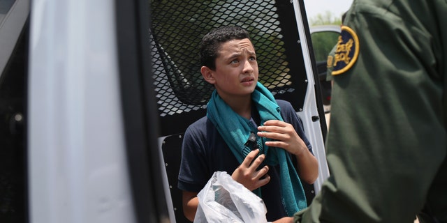 A U.S. Border Patrol agent prepares to take an unaccompanied Salvadorian minor, 13, to a processing center after he crossed the Rio Grande on July 24, 2014 in Mission, Texas.