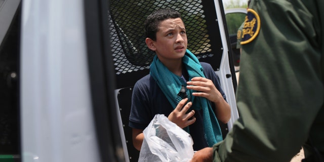 A U.S. Border Patrol agent prepares to take an unaccompanied Salvadorian minor, 13, to a processing center after he crossed the Rio Grande on July 24, 2014 in Mission, Texas.