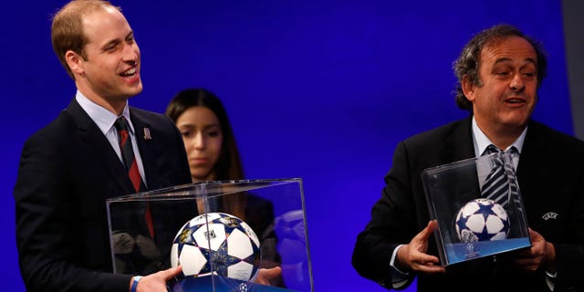 President of English Football Association Prince William, left, holding a football presented to him, reacts as UEFA President Michel Platini presents him with a mini soccer ball also after he addressed the delegates during the 37th Ordinary UEFA Congress in London, Friday, May 24, 2013. (AP Photo/Sang Tan)