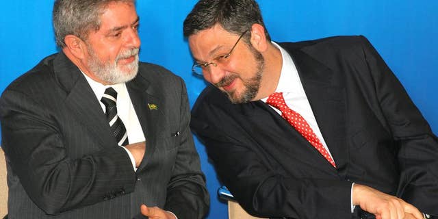 FILE - In this June 15, 2005 file photo, Brazil's President Luiz Inacio Lula da Silva, left, speaks with his Economy Minister Antonio Palocci during a ceremony at the presidential palace in Brasilia, Brazil. Palocci was arrested, police said on Monday, Sept. 26, 2016, the latest detention in connection with a wide-ranging investigation into a kickback scheme in state oil company Petrobras. This month investigators charged Lula with money laundering and corruption. (AP Photo/Eraldo Peres, File)