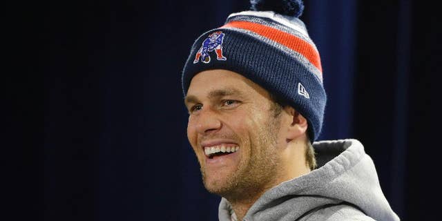 New England Patriots quarterback Tom Brady laughs as he listens to a reporter's questions during a media availability at the NFL football team's facility Wednesday, Nov. 26, 2014 in Foxborough, Mass. The Patriots will play the Green Bay Packers on Sunday in Wisconsin. (AP Photo/Stephan Savoia)