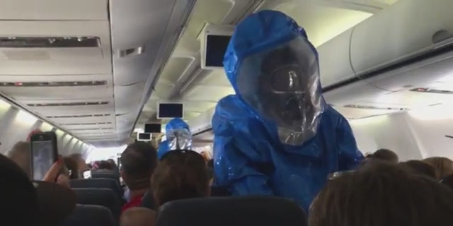 Emergency responders in hazmat suits on US Airways flight 845 from Philadelphia to Dominican Republic after a passenger caused a health scare.