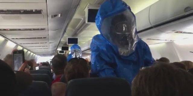 Emergency responders in hazmat suits on US Airways flight 845 from Philadelphia to Dominican Republic after a passenger caused a health scare.