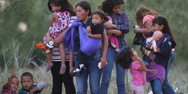 MISSION, TX - JULY 24: Central American immigrants await transportation to a U.S. Border Patrol processing center after crossing the Rio Grande from Mexico into the Texas on July 24, 2014 near Mission, Texas. Tens of thousands of undocumented immigrants, many of them families or unaccompanied minors, have crossed illegally into the United States this year and presented themselves to federal agents, causing a humanitarian crisis on the U.S.-Mexico border. The Rio Grande Sector of the border has the heaviest traffic of illegal crossings of the entire U.S.-Mexico border. (Photo by John Moore/Getty Images)