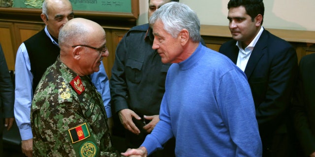 U.S. Secretary of Defense Chuck Hagel, right, shakes hands with Afghan Gen. Sher Mohammad Karimi, left, during a meeting at the International Security Assistance Force Headquarters (ISAF) on Saturday, Dec. 7, 2013 in Kabul, Afghanistan. Secretary Hagel made a stop in Afghanistan during his six-day trip to the Middle East. (AP Photo/Mark Wilson, Pool)