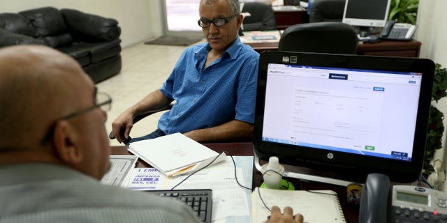 MIAMI, FL - FEBRUARY 13: Hisham Uadadeh (R) enrolls in a health insurance plan under the Affordable Care Act with the help of A. Michael Khoury at Leading Insurance Agency on February 13, 2014 in Miami, Florida. Numbers released by the government showed that about 3.3 million people signed up for health insurance plans under the Affordable Care Act through the end of January. (Photo by Joe Raedle/Getty Images)