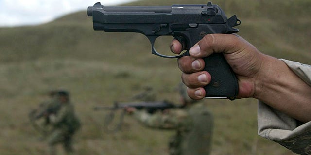 FILE: 2007: A U.S. army instructor fires with Colombian soldiers during a combat exercise in a southern Colombian.