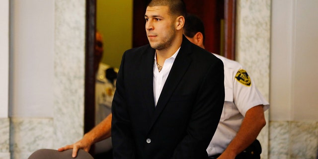 Aaron Hernandez is escorted into the courtroom on August 22, 2013 in North Attleboro, Massachusetts.
