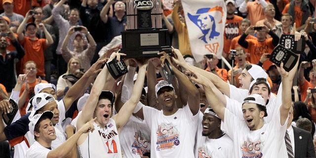 Virginia players celebrate with the trophy after defeating Duke in an NCAA college basketball game in the championship of the Atlantic Coast Conference tournament in Greensboro, N.C., Sunday, March 16, 2014. Virginia won 72-63. (AP Photo/Bob Leverone)