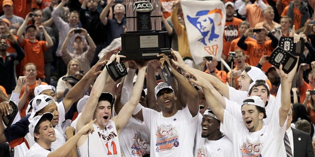 Virginia players celebrate with the trophy after defeating Duke in an NCAA college basketball game in the championship of the Atlantic Coast Conference tournament in Greensboro, N.C., Sunday, March 16, 2014. Virginia won 72-63. (AP Photo/Bob Leverone)