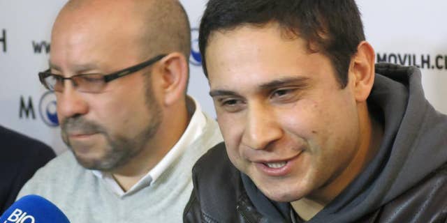 ADDS MONTH - Mauricio Ruiz, 24, sailor of the Chilean Navy, right, comes out publicly as gay during a press conference in Santiago, Chile, Wednesday Aug. 27, 2014. Ruiz who was accompanied by Rolando Jimenez, left, president of the Homosexual Liberation and Integration Movement, is the first member of the Chilean armed forces ever to come out publicly as gay with the approval of the High Command of the Chilean navy. (AP Photo/Eva Vergara)