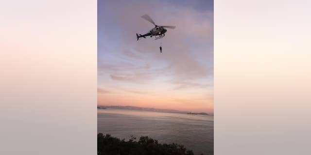 ADDS DAY AND DATE - In this photo provided by the National Park Service a California Highway Patrol helicopter lifts a suspect to safety during the rescue of two suspected vandals at Golden Gate National Recreation Area Thursday Feb. 26, 2015. Park service spokeswoman Alexandra Picavet says the men got stuck on a cliff at the waterfront of Fort Baker in Golden Gate National Recreation Area. She says they saw rangers approaching and tried to evade arrest by scrambling down a cliff near the water's edge. (AP Photo/U.S. National Park Service)