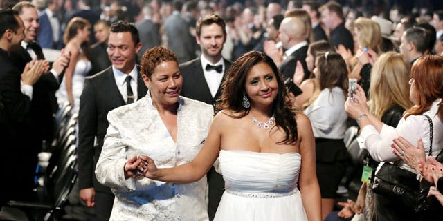 January 26, 2014: Audience members participate in a same sex wedding during a performance of "Same Love" by Macklemore and Ryan Lewis at the 56th annual Grammy Awards at Staples Center in Los Angeles. With Queen Latifah presiding from the stage and the music playing, 33 straight and gay couples lined the aisle dressed in wedding finery. Under Latifah's command, they exchanged rings near the end of Sunday night's show televised on CBS. (Photo by Matt Sayles/Invision/AP)