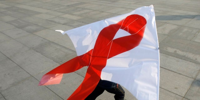 A child flies a kite with a red ribbon during a World AIDS Day event in Beijing November 30, 2008. There are about 700,000 cases of HIV/AIDS in China, according to official statistics. REUTERS/Jason Lee (CHINA)