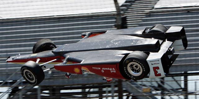 AP10ThingsToSee - The car driven by Helio Castroneves, of Brazil, is airborne after hitting a wall in the first turn during practice for the Indianapolis 500 auto race at Indianapolis Motor Speedway in Indianapolis on Wednesday, May 13, 2015. The car landed upside down before rolling onto its wheels but Castroneves was not seriously hurt. (AP Photo/Joe Watts)