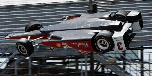 AP10ThingsToSee - The car driven by Helio Castroneves, of Brazil, is airborne after hitting a wall in the first turn during practice for the Indianapolis 500 auto race at Indianapolis Motor Speedway in Indianapolis on Wednesday, May 13, 2015. The car landed upside down before rolling onto its wheels but Castroneves was not seriously hurt. (AP Photo/Joe Watts)