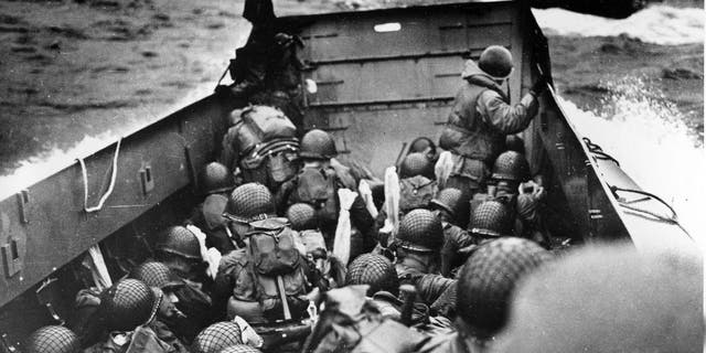 FILE - In this June 6, 2014 file photo, allied troops crouch behind the bulwarks of a landing craft as it nears Omaha Beach during a landing in Normandy, France. The D-Day invasion broke through Adolf Hitler’s western defenses and led to the liberation of France from Nazi occupation just as the Soviet Army was making advances in the east, turning the tide of the war in the Allies’ favor. Allied troops landed on the Normandy coast of France in tremendous strength by cloudy daylight today and stormed several miles inland with tanks and infantry in the grand assault which Gen. Dwight D. Eisenhower called a crusade in which “we will accept nothing less than full victory.”(AP Photo/U.S. Coast Guard, File)