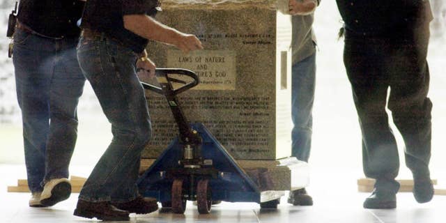 Crews remove a Ten Commandments monument from an Alabama courthouse in 2003 after judge Roy Moore was stripped of his position for refusing to take down the statue. (AP Photo/Bill Haber)