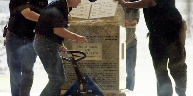 Crews remove a Ten Commandments monument from an Alabama courthouse in 2003 after judge Roy Moore was stripped of his position for refusing to take down the statue. (AP Photo/Bill Haber)