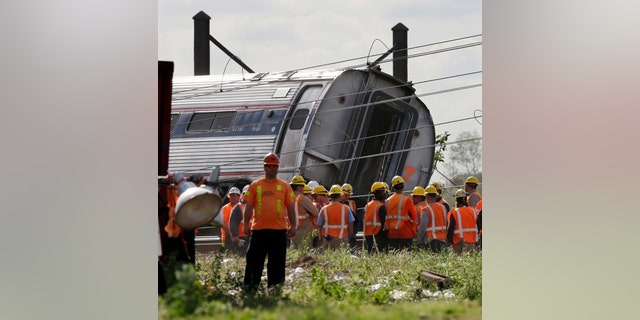 Emergency personnel gather near the scene of a deadly train derailment, Wednesday, May 13, 2015, in Philadelphia.