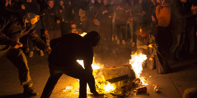 People burn litter as they protest in Paris, Sunday, April 23, 2017.