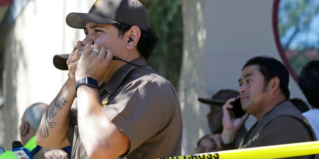 UPS workers gather outside a UPS package delivery warehouse where a shooting took place.
