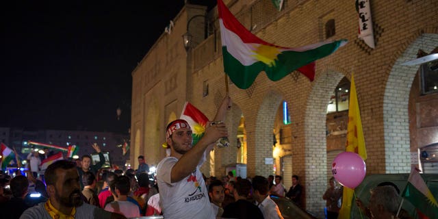 A man waves the Kurdish flag in the streets of Irbil after polling stations closed on Monday, Sept. 25, 2017. The Kurds of Iraq were voting in a referendum on support for independence.